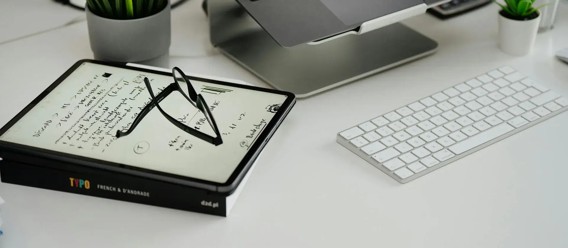 Bureau de recherche moderne avec carnet, ordinateur et plantes, ambiance scientifique sobre.